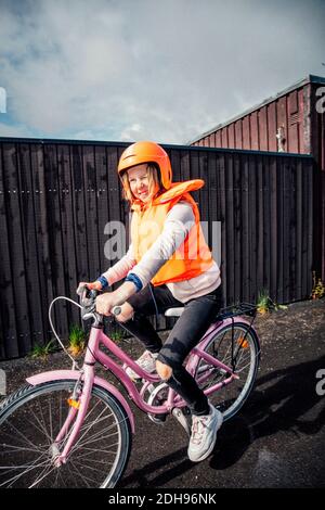 Ragazza sorridente in bicicletta su strada Foto Stock