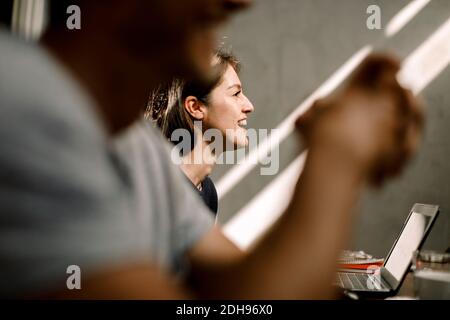 Imprenditrice sorridente seduto in ufficio Foto Stock