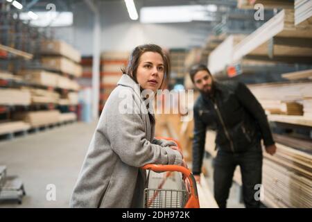 Coppia che guarda lontano mentre si trova nel magazzino di negozi di hardware Foto Stock