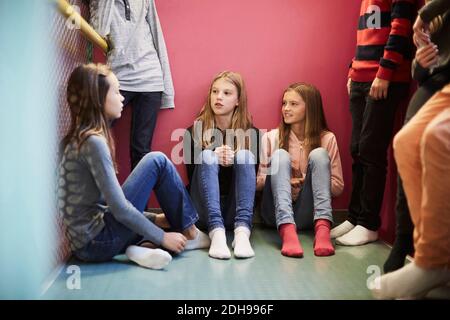 Ragazze e ragazzi che discutano nella scuola media Foto Stock