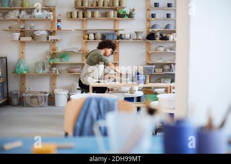 Vista laterale della ceramica di apprendimento donna in studio d'arte Foto Stock