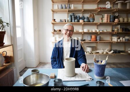 Ritratto di donna matura sorridente seduta in classe d'arte Foto Stock
