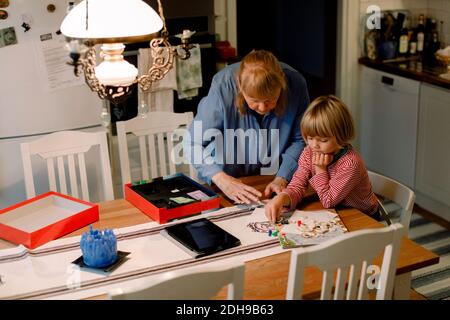 Donna anziana che gioca a tavola con il nipote a casa Foto Stock