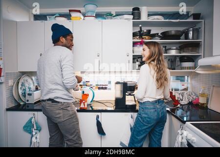 Felici giovani coinquilini che cucinano in cucina Foto Stock