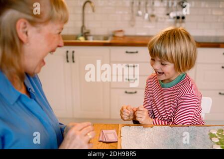 Buon nipote giocare a tavola con nonna a casa Foto Stock