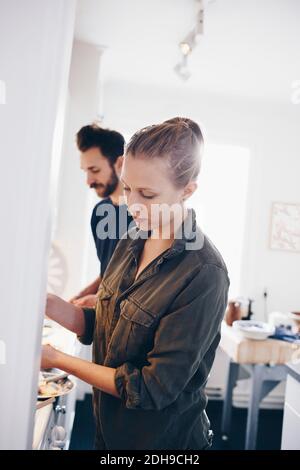Tilt shot di coppia che lavora in cucina a casa Foto Stock