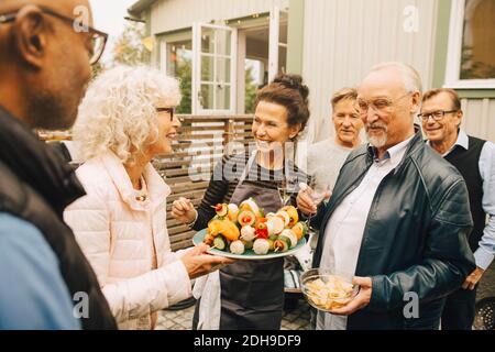 Sorridenti donne e uomini anziani che godono di festa in giardino Foto Stock