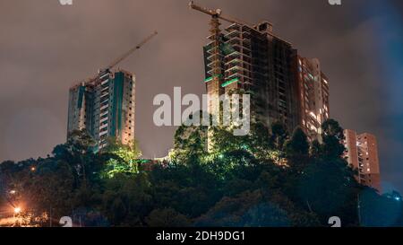 Un paio di edifici ancora in costruzione anche durante la notte, la popolazione sta crescendo molto velocemente Foto Stock