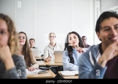 Studenti multietnici di sesso maschile e femminile seduti alla scrivania in classe Foto Stock