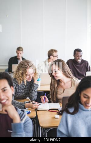 Le studentesse discutono oltre il libro in classe Foto Stock