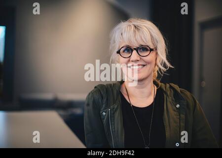 Ritratto di donna d'affari felice che indossa occhiali in ufficio Foto Stock