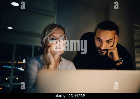 Colleghi multietnici che staranno al computer portatile durante la riunione in ufficio Foto Stock