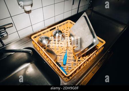 Vista ad alto angolo del cesto con utensili da cucina in cucina banco nel caffè Foto Stock