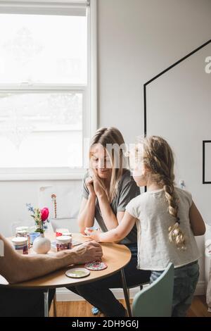 Figlia che serve il tè della madre al tavolo nella sala giochi Foto Stock