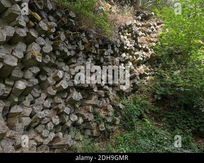 La parete del prisma di basalto a Gangolfsberg è costituita da colonne di basalto impilate di legno con un diametro di 30 - 40 cm, Oberelsbach, contea di Rhön-Grabfeld, Baviera Foto Stock