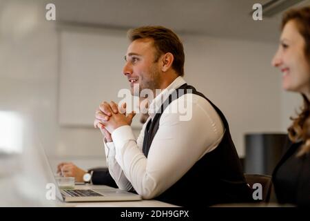 Uomo d'affari sorridente con le mani aggrappate a discutere in riunione in ufficio