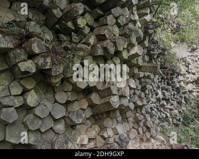 La parete del prisma di basalto a Gangolfsberg è costituita da colonne di basalto impilate di legno con un diametro di 30 - 40 cm, Oberelsbach, contea di Rhön-Grabfeld, Baviera Foto Stock