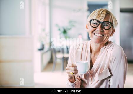 Ritratto di donna sorridente di bere il caffè a casa Foto Stock