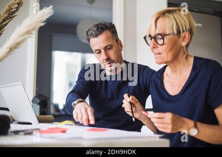 Uomo e donna che hanno una conversazione lavorando a casa Foto Stock