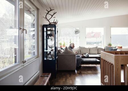 Un uomo anziano a tutta lunghezza seduto sul divano nel soggiorno camera a casa Foto Stock