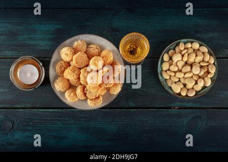 Amaretti, biscotti tradizionali italiani alle mandorle, con un bicchiere di liquore amaretto, sparato dall'alto Foto Stock