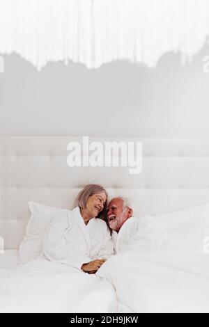 Felice romantica coppia senior a letto in camera d'albergo Foto Stock