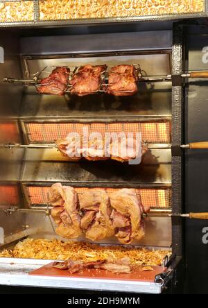 Tradizionale cibo di Natale tedesco carne di maiale grigliata Spiessbraten a Natale Mercato ad Hannover, Germania Foto Stock