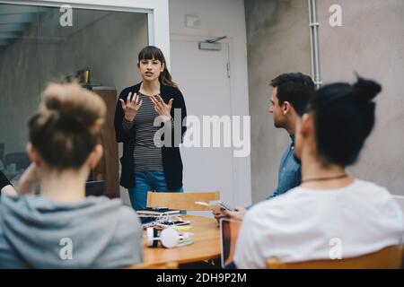 Programmatore di computer femminile che dà la presentazione ai colleghi in ufficio Foto Stock