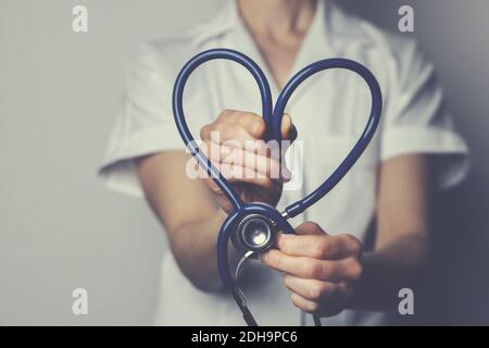 salute lavoro amore concetto. operaio medico con stetoscopio a forma di cuore Foto Stock