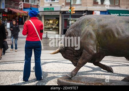 Istanbul, Turchia - 18 ottobre 2011 : un momento divertente di quando una giovane donna in tuta rossa stava per essere orlata dalla statua di un toro a Kadikoy, Foto Stock