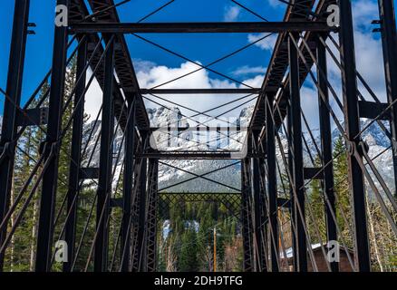 Canmore Engine Bridge nelle prime stagioni invernali giorno di sole mattina. Drift ghiaccio galleggiante sul fiume Bow. Cielo blu chiaro, neve coperto Monte Rundle Foto Stock