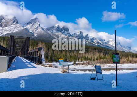 Canmore Engine Bridge nelle prime stagioni invernali giorno di sole mattina. Drift ghiaccio galleggiante sul fiume Bow. Cielo blu chiaro, neve coperto Monte Rundle Foto Stock