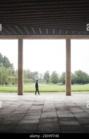 Vista a metà distanza dell'uomo che cammina contro il verde paesaggio Foto Stock