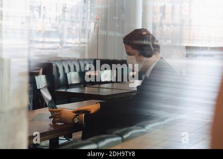 Uomo che indossa una maschera che lavora al bar Foto Stock