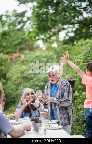 Famiglia multigenerazionale che gusterete il pranzo nel cortile posteriore Foto Stock