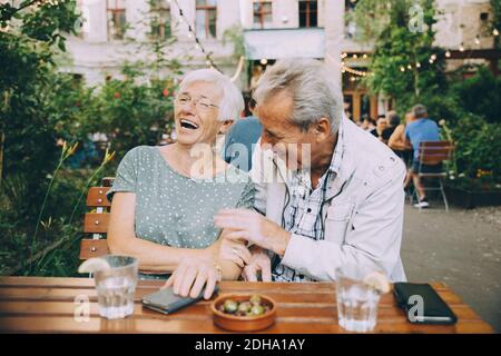 Sorridente turista coppia senior seduto al ristorante in città Foto Stock