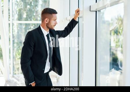 Profilo di uomo d'affari sicuro in elegante suite in moderno ufficio creativo Foto Stock