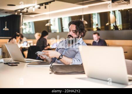 L'imprenditore maschile che pianifica le strategie di affari mentre lavora in ufficio Foto Stock