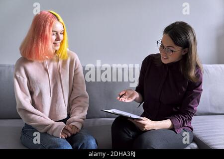 Ragazza teen che dà l'intervista al lavoratore sociale. Psicologo scolastico che parla con lo studente Foto Stock