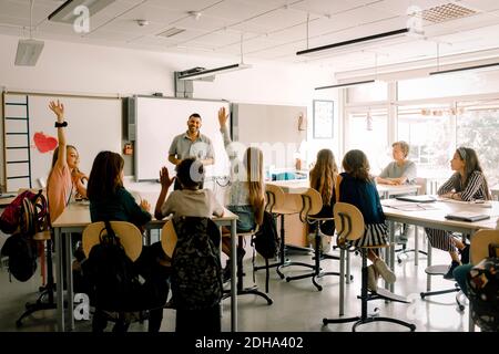 Studenti di sesso maschile e femminile con insegnante in classe Foto Stock