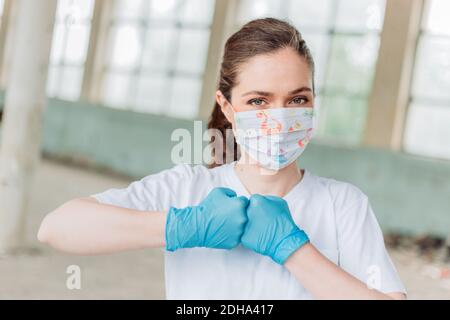 Giovane bionda femmina medico facendo pugno. Corona lotta Foto Stock