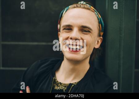 Ritratto di giovane sorridente in piedi contro il muro Foto Stock