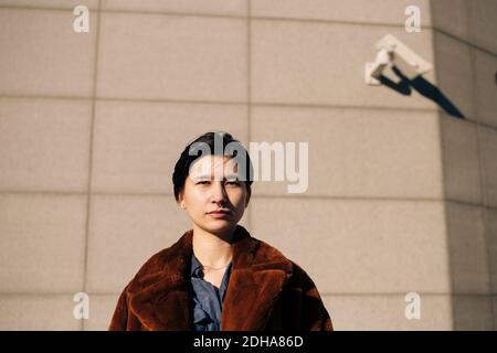 Ritratto di donna in piedi contro la parete Foto Stock