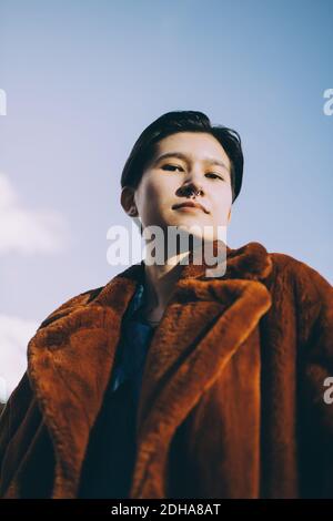 Ritratto a basso angolo della donna contro il cielo Foto Stock