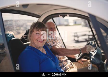 Ritratto di donna anziana sorridente e di uomo che gode di un giro in auto il giorno di sole Foto Stock