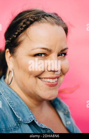 Ritratto di felice donna matura su sfondo rosa Foto Stock