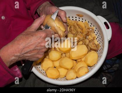 Vecchia donna che peeling potatos, Berlino Foto Stock