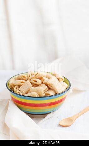 Granoturco croccante in una ciotola di argilla su uno sfondo chiaro. Cereali sani per la colazione. Cuscinetti Amaranth con crema di riempimento spazio copia, still life, selective f Foto Stock