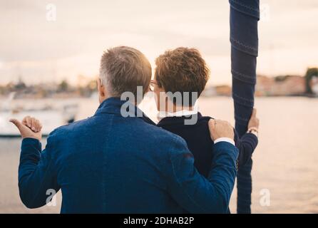 Vista posteriore della coppia senior che parla mentre si viaggia in yacht Foto Stock