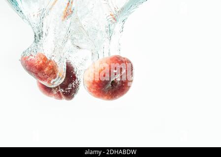 Mazzo di pesche di ciambelle isolate su bianco, spruzzando in acqua. Foto Stock